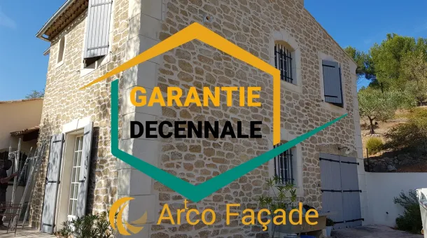 logo garantie decennale avec en arriere plan une maison ayant une façade imitation pierre