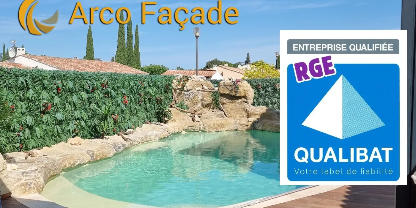 piscine entourée de faux rochers artificiels avec logo RGE - QUALIBAT
