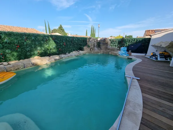 piscince avec faux rochers artificiels et terasse en bois