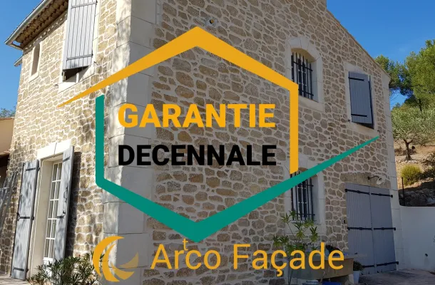 logo garantie decennale avec en arriere plan une maison ayant une façade imitation pierre