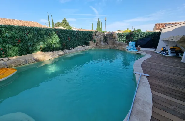 piscince avec faux rochers artificiels et terasse en bois